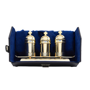 Estuche con tres jarritas doradas sobre bande...